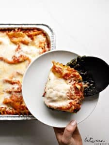 placing a slice of lasagna onto a plate