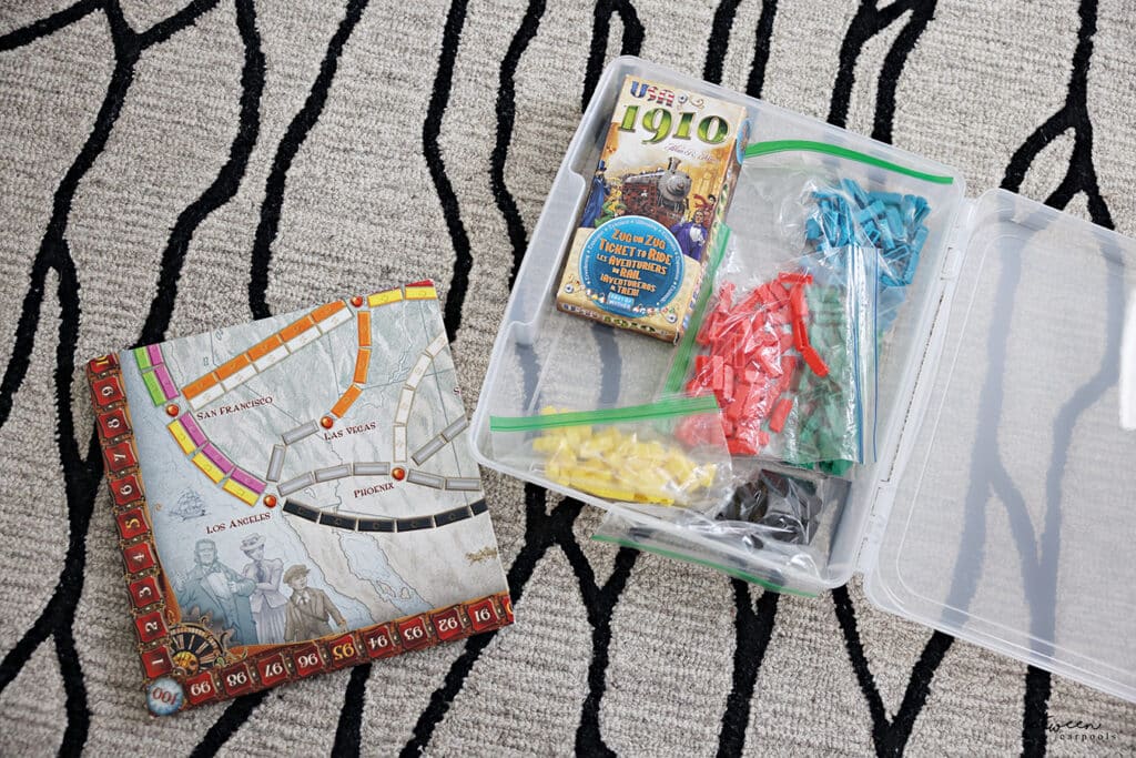 an open IRIS game box on carpet - with toy pieces and a game board