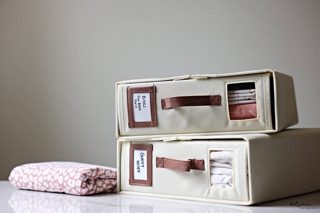 two bed sheet organizers, with a set of linen in each, labeled