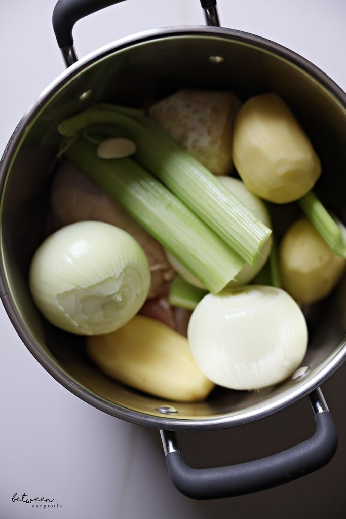 An 8 quart pot with chicken and all vegetables for Cream of Chicken Soup.