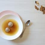 Two Matzah balls in a bowl of chicken soup.