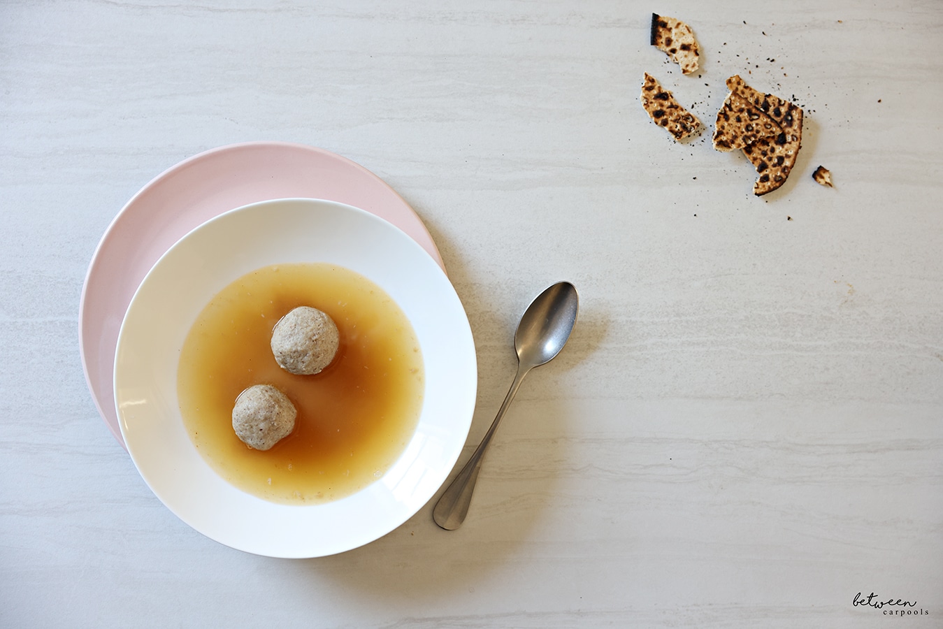 Two Matzah balls in a bowl of chicken soup.