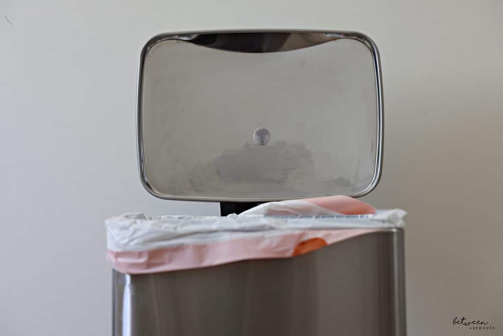 A Felt Furniture Pad with scented oil on the underside of a stainless trash can lid.