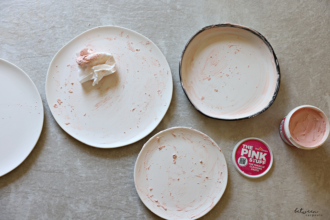 Three matte white plates, each scrubbed with The Pink Stuff.