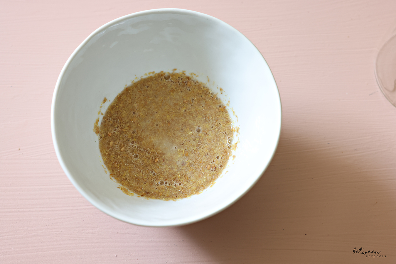 Flaxseed meal and water, mixed, in a small white bowl.