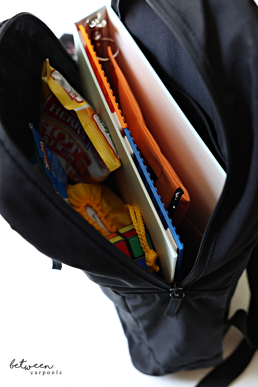 Lego binder in a backpack with snacks and toys.