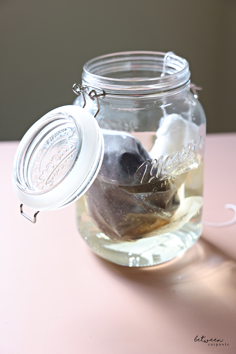 Coffee grounds in a cold brew bag in a wide-mouth glass jar with water.