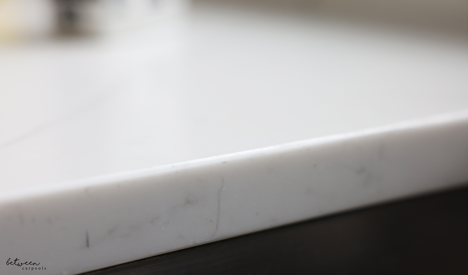 Gray marks on Quartz countertop edge - around a kitchen sink.