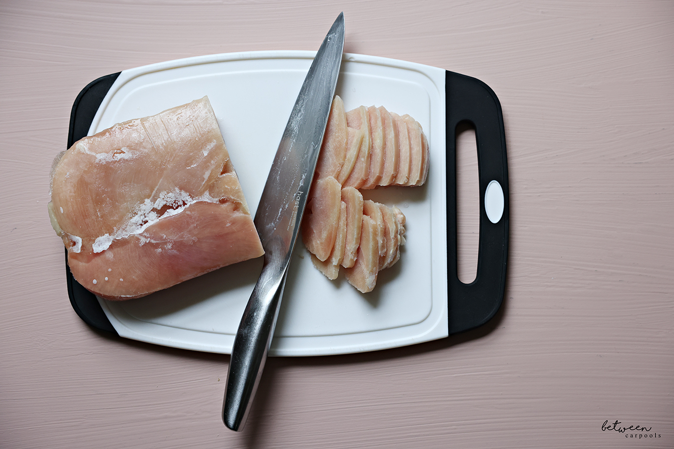 a frozen Family Pack of Chicken Cutlets and slices of frozen chicken on a cutting board with a stainless knife.