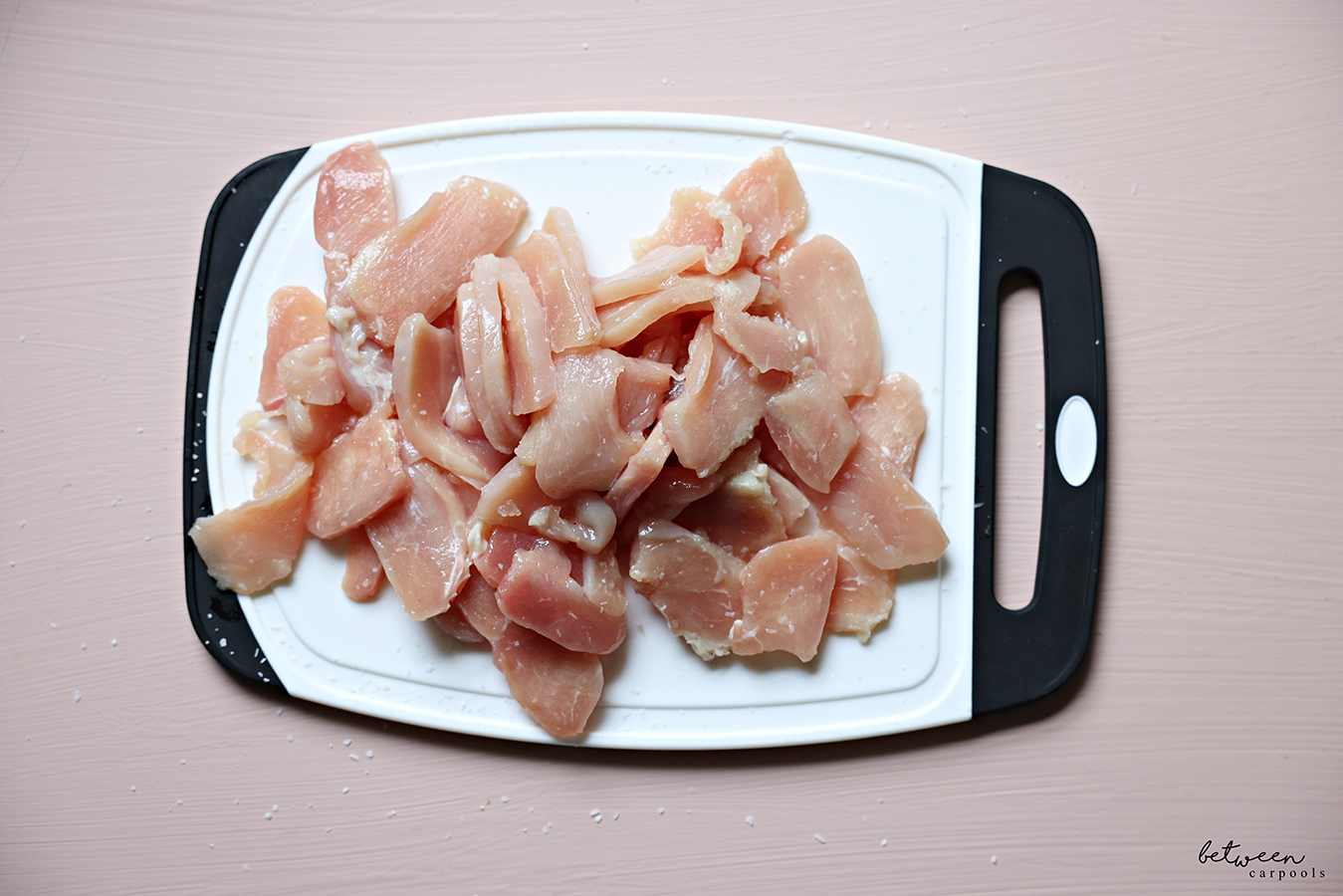 Thawed slices of chicken cutlets on a cutting board.