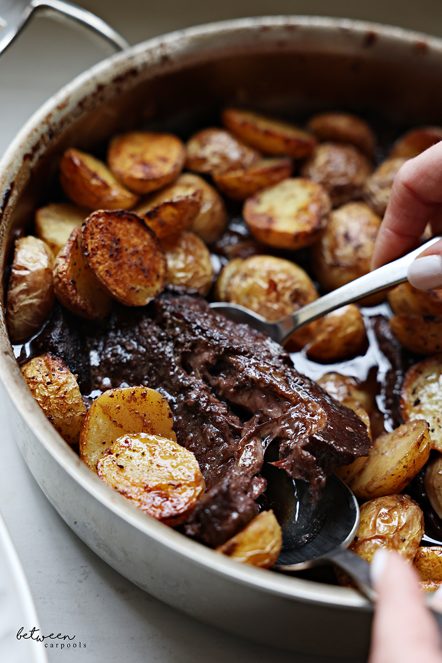 Closeup of boneless flanken and potatoes with red wine in a pot.