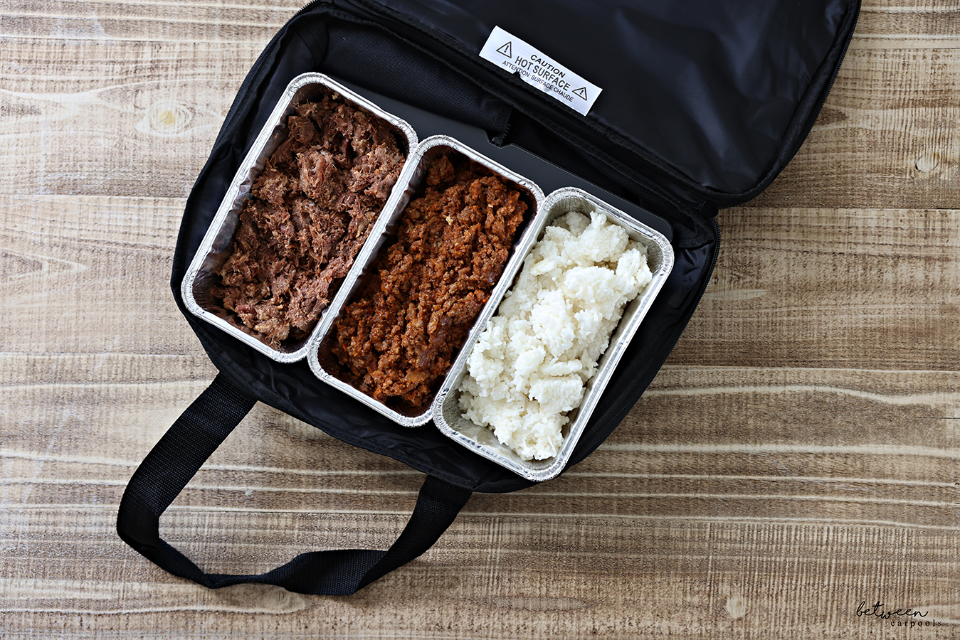 Three disposable loaf pans with precooked food in a HOTLOGIC Max Large Portable Electric Food Heater. Open, Top View.