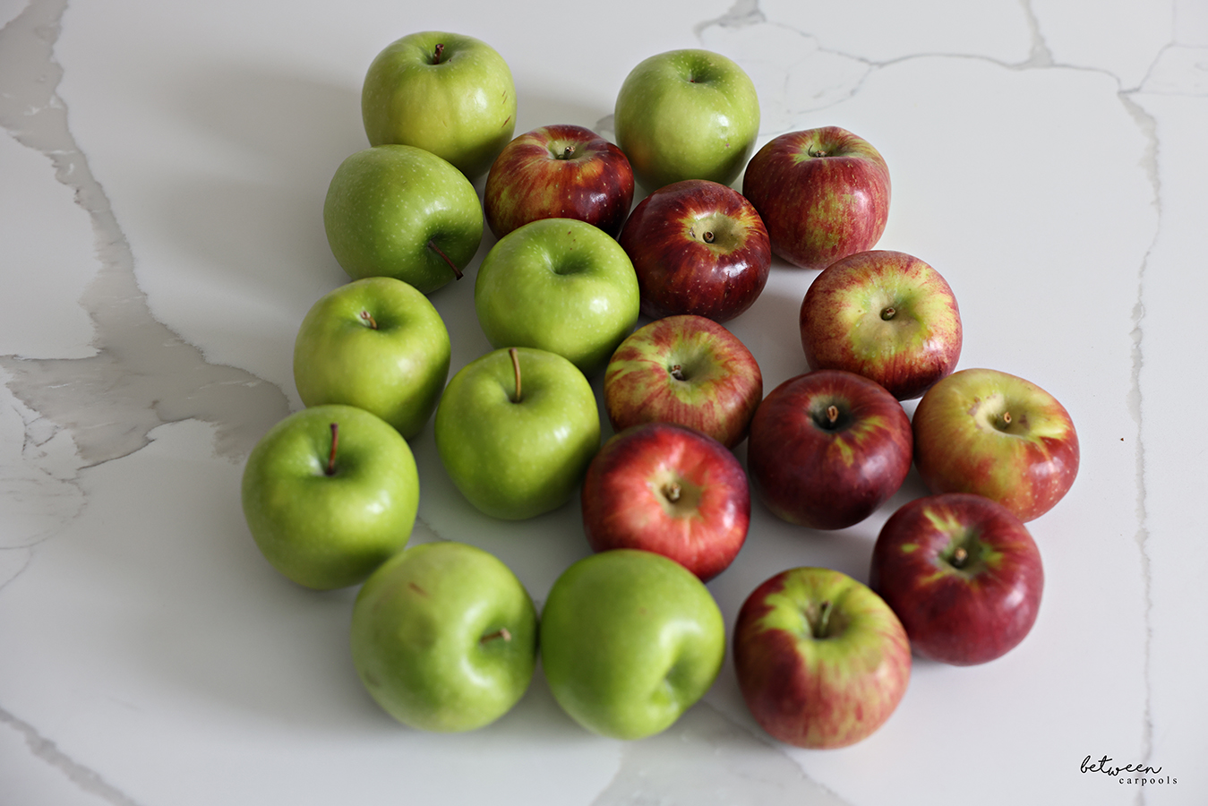 Granny Smith and Honeycrisp apples on a kitchen counter.