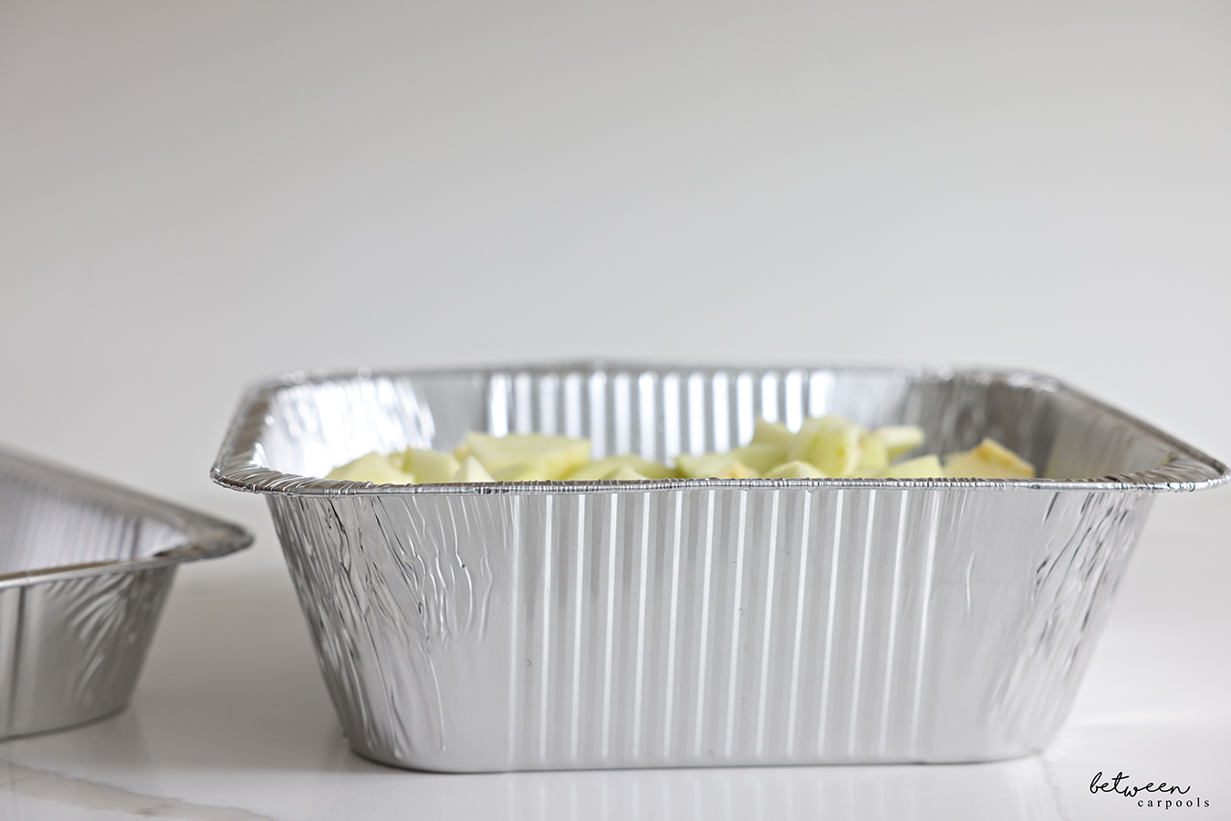 Side view of chopped apples in a deep 9x13 pan.