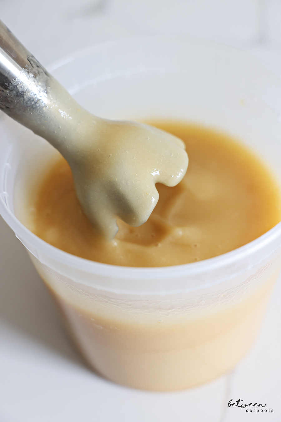 Blended applesauce in a deep deli container.