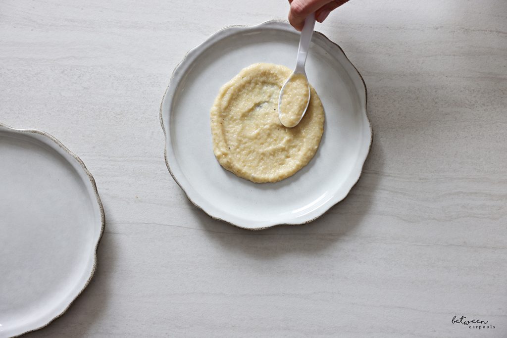 Plating eggplant puree in a circular shape on a plate.