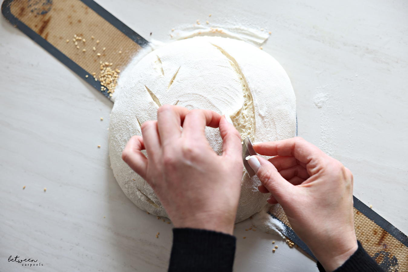 Cutting into the side of an ear on a sourdough loaf.